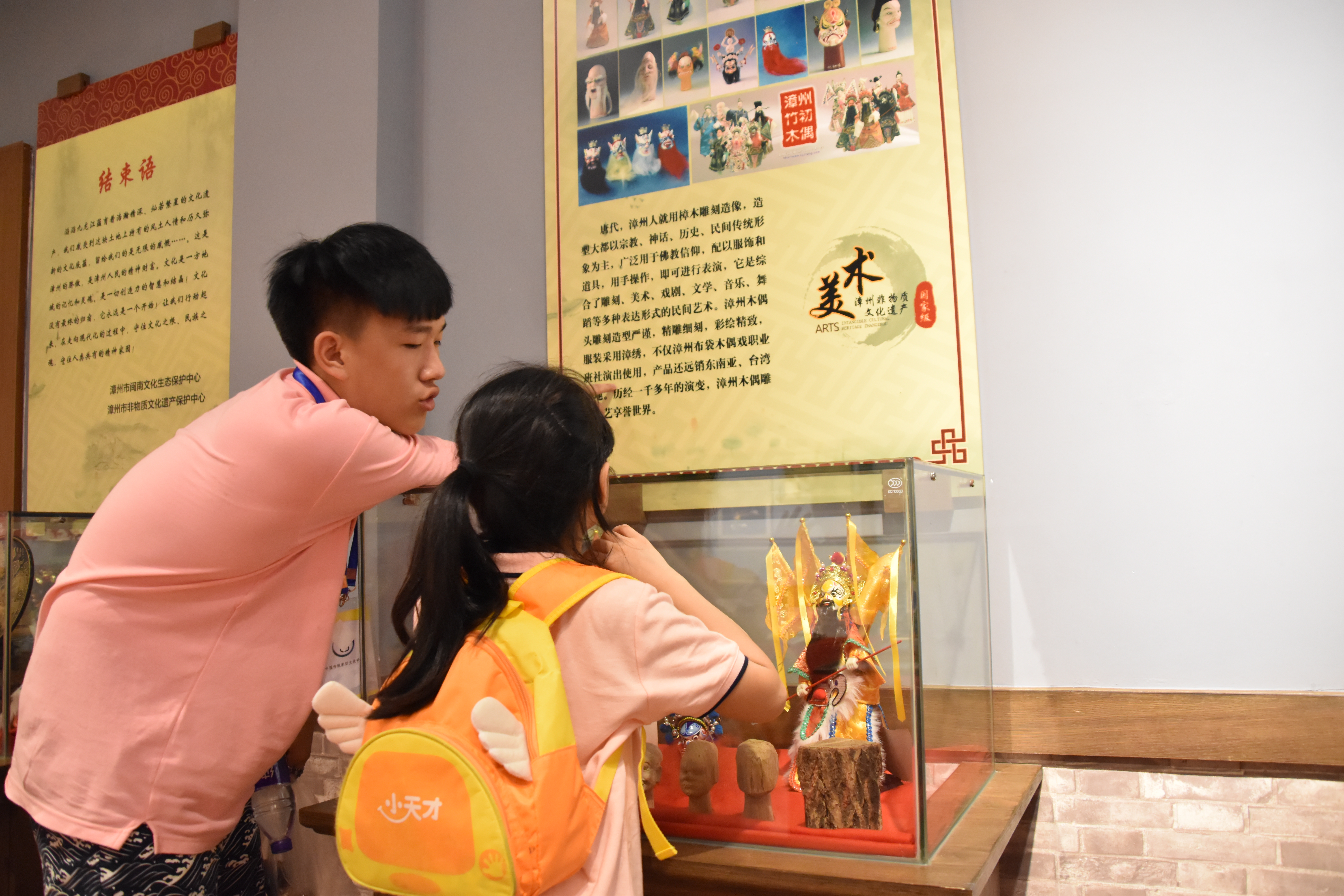 “家长”及孩子正在非物质文化遗产展示馆寻访